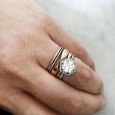 a woman's hand with two rings on it and a diamond in the middle