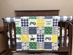 a baby crib with a farm life quilt on it