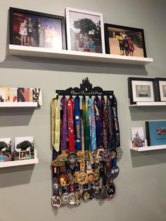 several medals are hanging on the wall with pictures and frames above them, along with other items