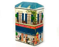 a tin canister with an image of a cafe on it