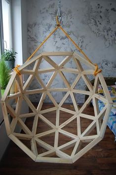 a wooden structure hanging from a rope in front of a window