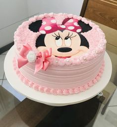 a minnie mouse cake with pink frosting on top