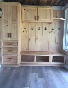 an empty room with some wooden cabinets and drawers on the wall next to a window