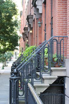 the stairs lead to an apartment building with plants growing on it's balconies