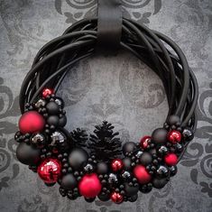 a black wreath with red and silver ornaments