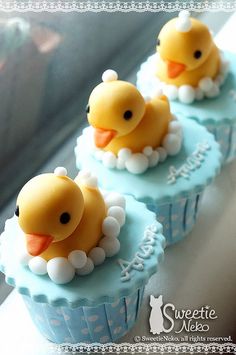 three cupcakes with rubber ducks on them