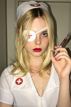 a woman in white nurse uniform holding a pen and scissors to her eye with the word f painted on it