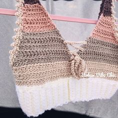 a crocheted bralet hanging on a clothes line with the top part off