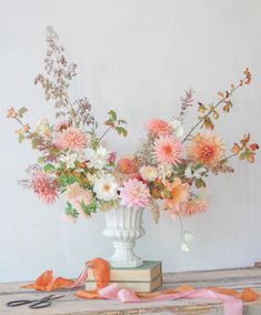 a vase filled with lots of flowers sitting on top of a table next to scissors