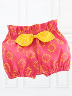 a pink shorts with yellow bows hanging from it's side, and the bottom part of the shorts is made out of fabric