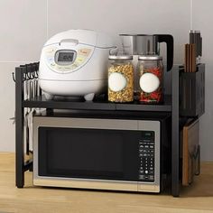 a microwave oven sitting on top of a shelf next to other kitchen appliances and utensils