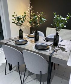 two vases with flowers are sitting on the table