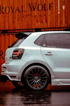 a white car parked in front of a shipping container