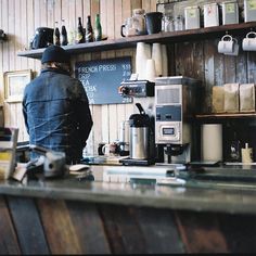 a man standing at a counter in a coffee shop