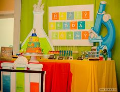 a science themed birthday party with colorful decorations and cake on the table for children's birthday