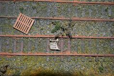 an overhead view of a shopping cart on the side of a brick wall with grates