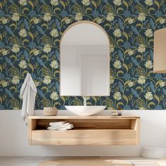 a bathroom with a mirror, sink and wallpaper on the walls in blue colors