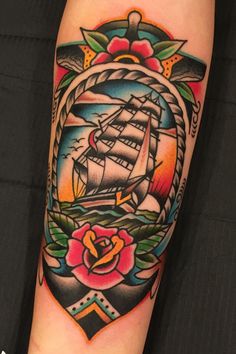 an old school style tattoo with a ship in the center and roses on it's arm