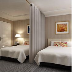 two beds in a hotel room with white linens and striped pillows on the bed