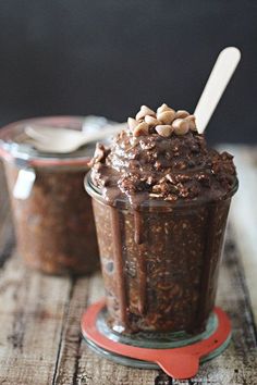 two jars filled with chocolate pudding on top of a table