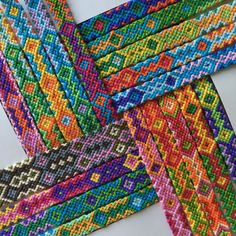 four different colors of beaded fabric are arranged in the shape of a cross - stitch pattern