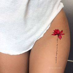 a woman's thigh with a red flower tattoo on the lower part of her leg