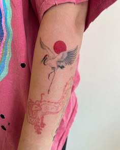 a woman's arm with a tattoo on it and a bird in the middle