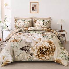 a bed with a flowered comforter and matching pillow cases on top of it