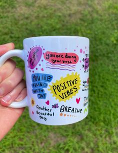 a person holding a coffee mug in their hand with some writing on the inside of it