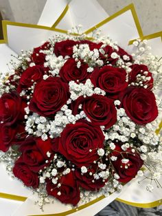 a bouquet of red roses and baby's breath