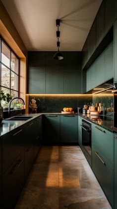 a kitchen with green cabinets and counter tops next to a large window that looks out onto the outdoors