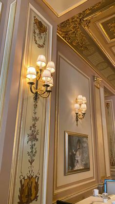 an ornately decorated dining room with chandeliers and paintings on the walls,