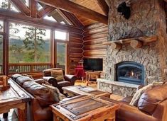 a living room filled with furniture and a fire place in front of a stone fireplace