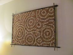 a wall hanging made out of coins with metal bars on the bottom and one side