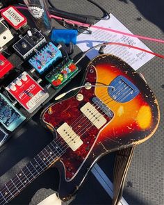 an electric guitar sitting on top of a table next to some other musical instruments and wires