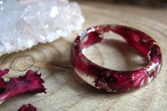 Burgundy Resin Ring with copper flakes. A thin smooth band ring made with preserved real burgundy Carnation petals and copper metallic flakes in clear Eco resin. Burgundy Carnations symbolize fascination, love, admiration, and memorability. I love to borrow rich seemingly chaotic forms and colors from the natural world, pieces of micro habitat, the world in miniature, the little reminders of our true place Nature is always amazing, brings us brightness and good vibrations, reconnects us with ear Burgundy Carnations, Nature Engagement Ring, Red Carnation, Romantic Rings, Good Vibrations, Angel Gifts, Carnation Flower, Eco Resin, Flower Resin