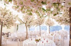 the tables are set with white linens and floral centerpieces