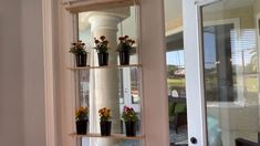 a shelf with flowers on it in front of a door