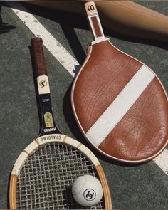 a tennis racket and ball on the ground