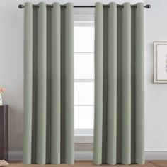 the curtains in this room are made from light green fabric and have an open grommet