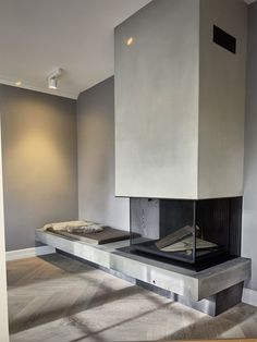 an empty room with a fireplace in the middle and no one around it on the floor