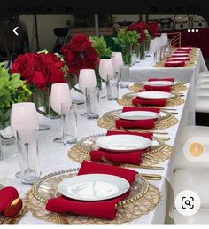 the table is set with red and white place settings