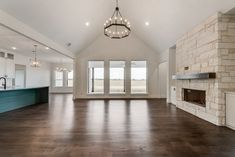 an empty living room with wood flooring and large open space to the dining area