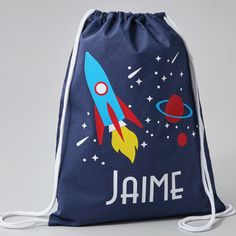 a drawstring bag with an image of a rocket ship and planets on it