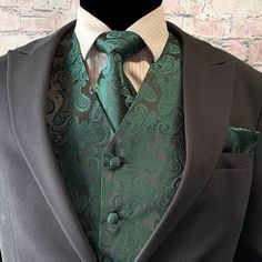 a man wearing a suit and tie with a green paisley print on the lapel