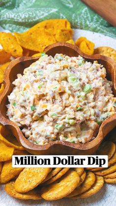 a wooden bowl filled with coleslaw and crackers on top of a plate