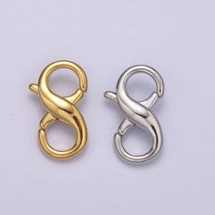 two gold and silver metal clasps on a white background