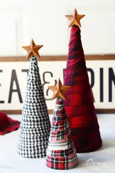 three christmas trees made out of fabric and wood are sitting on a table with the words eat & drink written above them