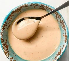 a spoon in a bowl filled with cream sauce