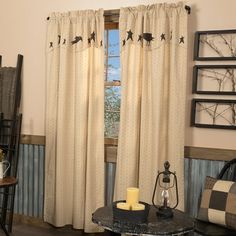 a living room filled with furniture and a large window covered in curtains that have birds on them